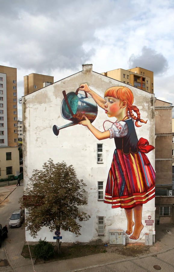 A wall mural girl waters a real tree in Poland. Photo by Natalia Rak on BoredPanda.com