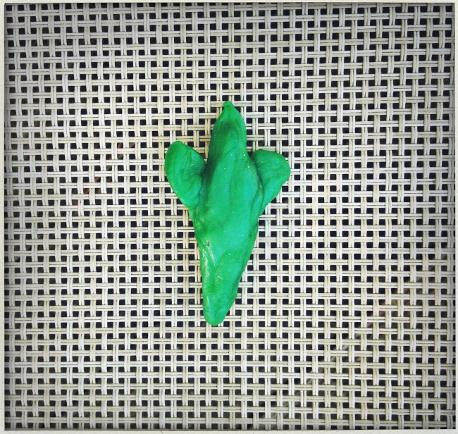 A small green bird made of wax.